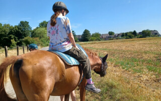 Ein Mädchen sitzt auf dem Pferd.