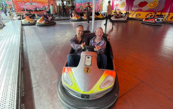Ein Foto von Betreuer und Bewohner auf dem Autoscooter
